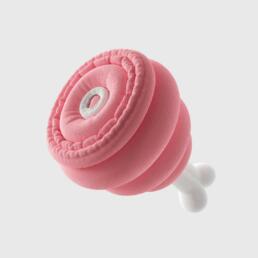 Pink, plush-looking ham-shaped object with a white bone detail on a neutral background.